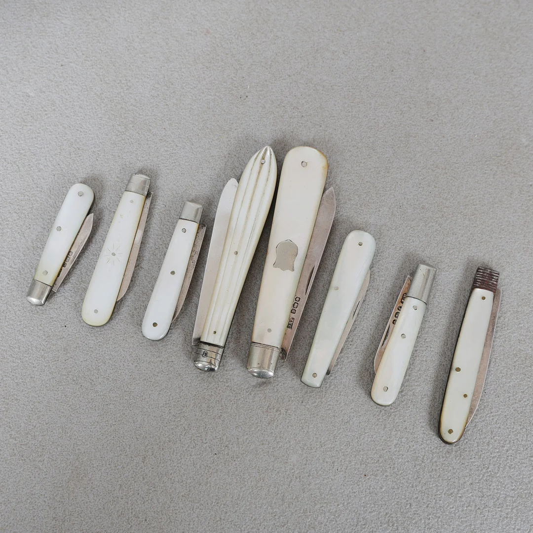 A COLLECTION OF EIGHT MOTHER OF PEARL AND SILVER BLADED FRUIT KNIVES (8). — Silver — Bishop & Miller