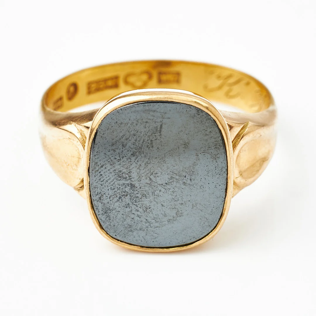 KLACKRING, 23 k guld, planslipad hematit i 18 k guldmontering, AB Juvelerare J Petterssons Eftr. Stockholm 1914. — Rings — Stockholms Auktionsverk Magasin 5