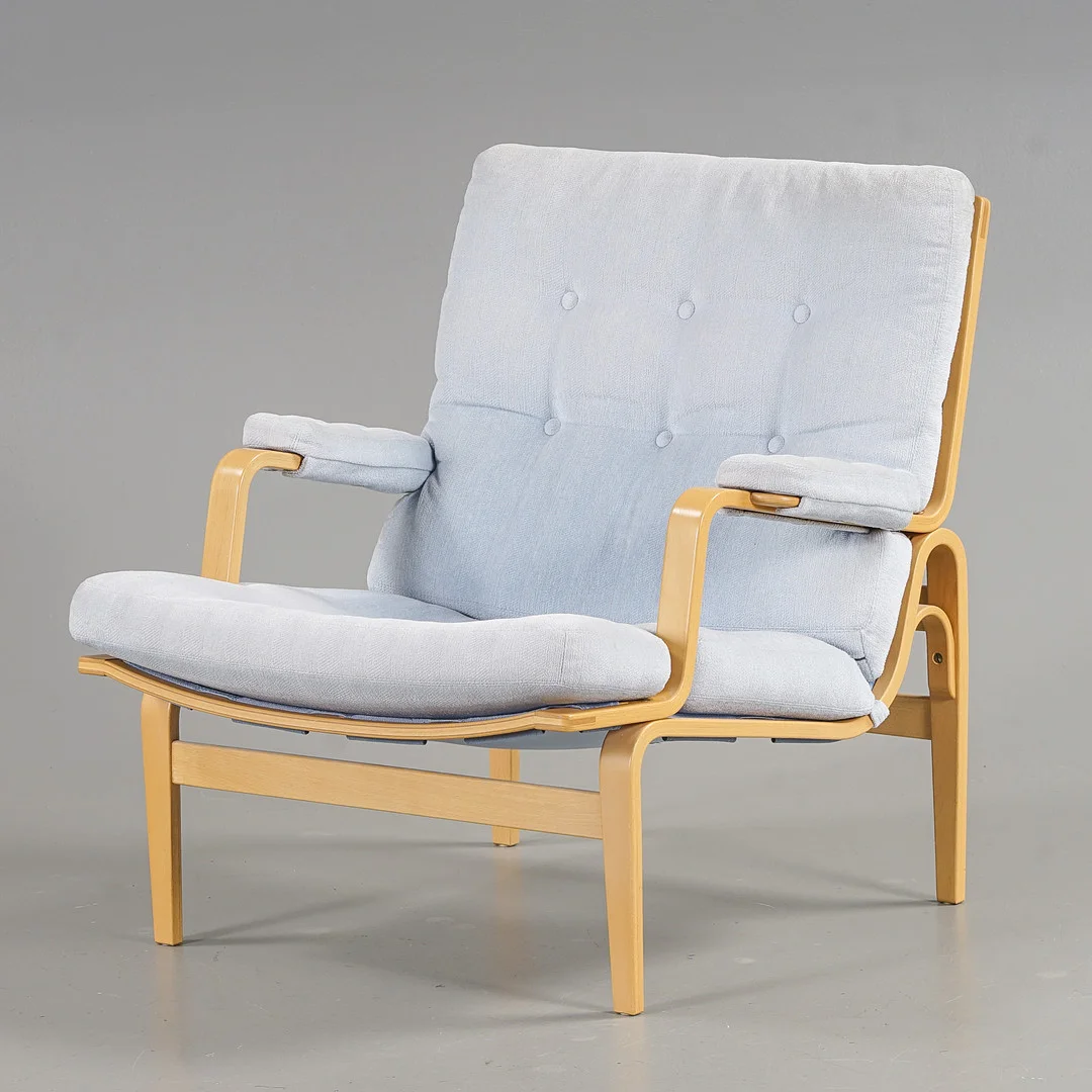 BRUNO MATHSSON. Fåtölj "Ingrid" Bok, ljusblå textilklädsel, Dux, 1900-talets andra hälft. — Armchairs & Chairs — Karlstad Hammarö Auktionsverk