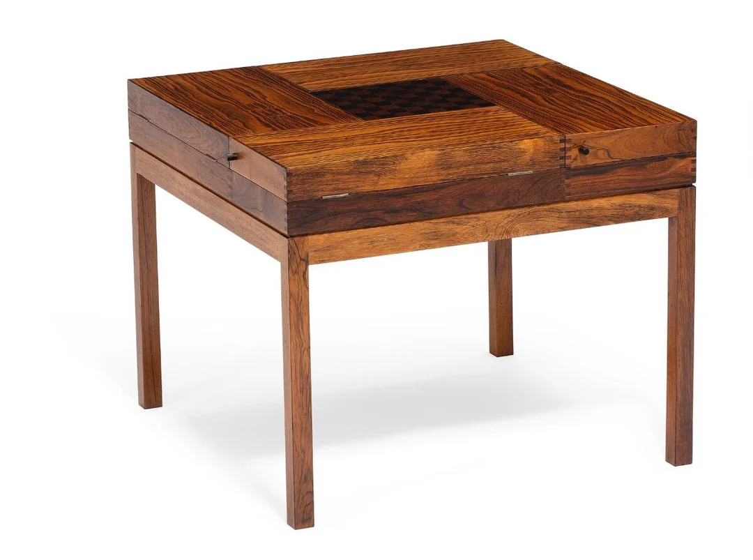 A square tobacco/games table of Brazilian rosewood and macassar with brass fittings. Top with reversible lid in centre, one side with chess board. Four rectangular fold-out compartments. Interior with black leather and adjustable space dividers. Designed 1966. Made approx. 1970s by cabinetmaker Willy Beck. H. 51.5 cm. W./L. 63 cm. — Modern Furniture — Bruun Rasmussen