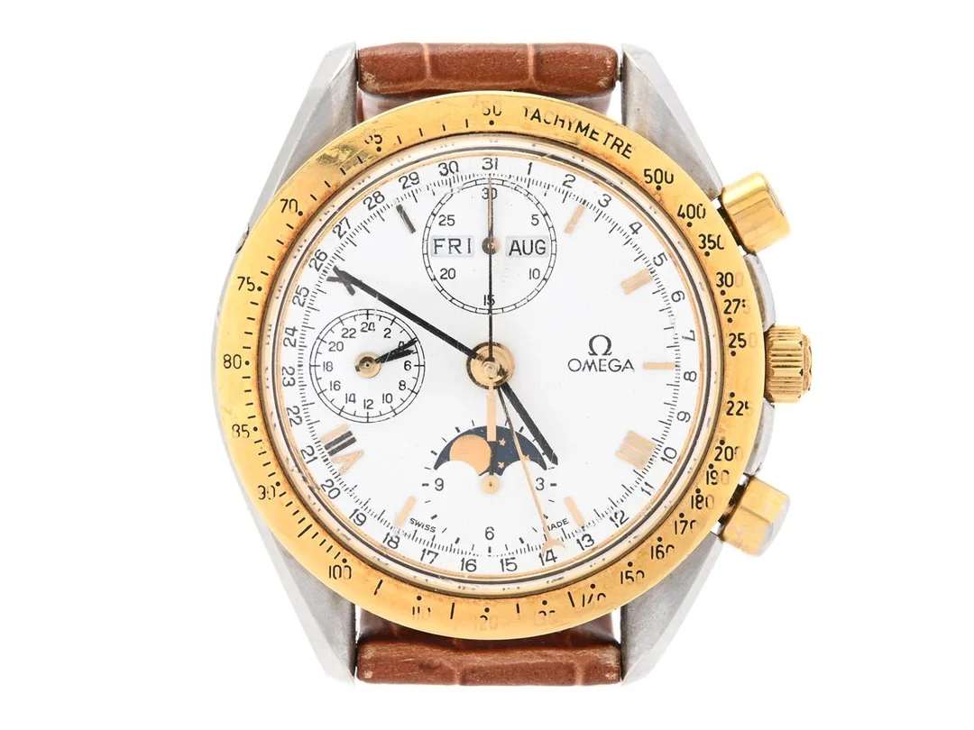 OMEGA, Speedmaster Classic, "Tachymetre", Cal 1151 (Valjoux 7751), Serie nr. 51653275, PIC nr. 3730.30.01, Ref nr. DA 175.0034, Boett nr. 175.0034 (K.B.), kronograf, herrur, 39 mm, stål/guld, automatisk, plexiglas, dag, datum, månad, månfas, 24-timmarsvisning, läderband, originalspänne i doublé, ca 1989, box (skadad), ytterkartong. — Klockor/Omega — Kaplans