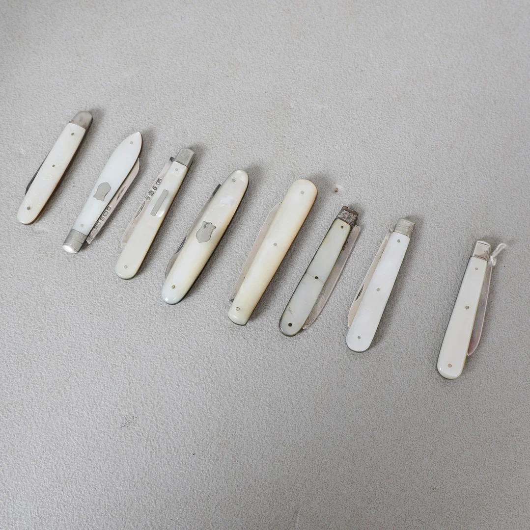 A COLLECTION OF EIGHT MOTHER OF PEARL AND SILVER BLADED FRUIT KNIVES (8). — Silver — Bishop & Miller