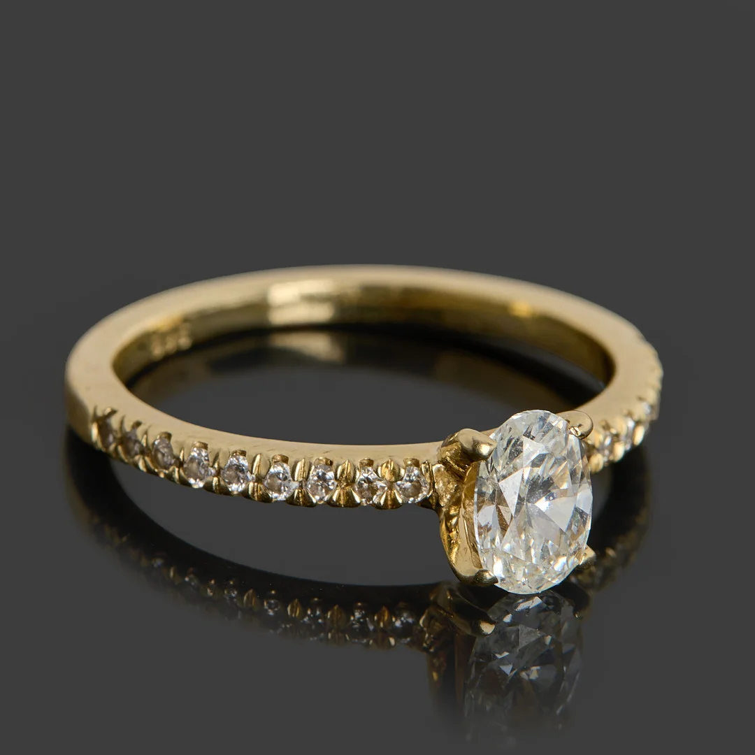 RING, 14k guld dekorerat med en ovalslipad diamant ca 0.54ct, 18 st briljanter totalt ca 0.18ct, certifikat medföljer. — Rings — Crafoord Auktioner Stockholm