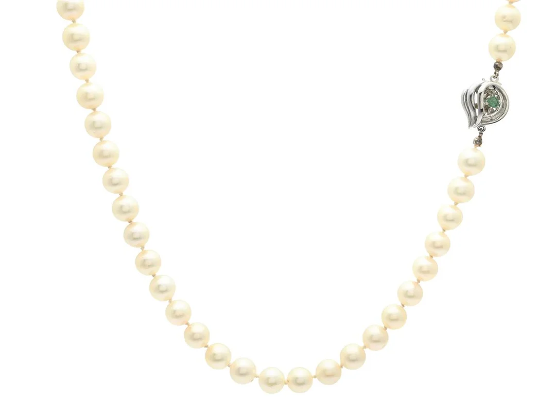 PÄRLCOLLIER, odlade pärlor ca 7,1-7,2 mm, lås 18K vitguld, rundslipad smaragd, längd 61 cm, vikt 41,6 g, slitet silke, inneslutningar som når ytan. — Smycken/Pärlcollier — Kaplans