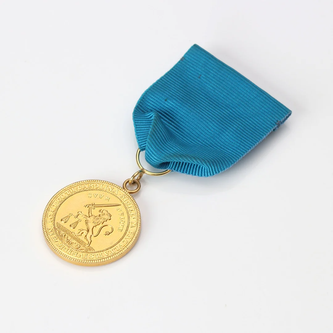 GULDMEDALJ. 18k guld, Juridiska fakulteten, Lunds universitet. Totalvikt ca 20,4 gram. — Orders & Medals — Skånes Auktionsverk