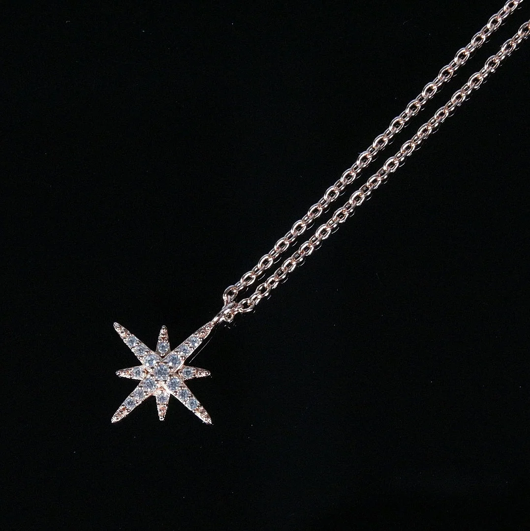 MERALIN JEWELRY. Halskette mit Sternanhänger, besetzt mit Zirkonia, 925er Sterlingsilber, rosévergoldet, Italien. — Necklace — Stockholms Auktionsverk Düsseldorf/Neuss