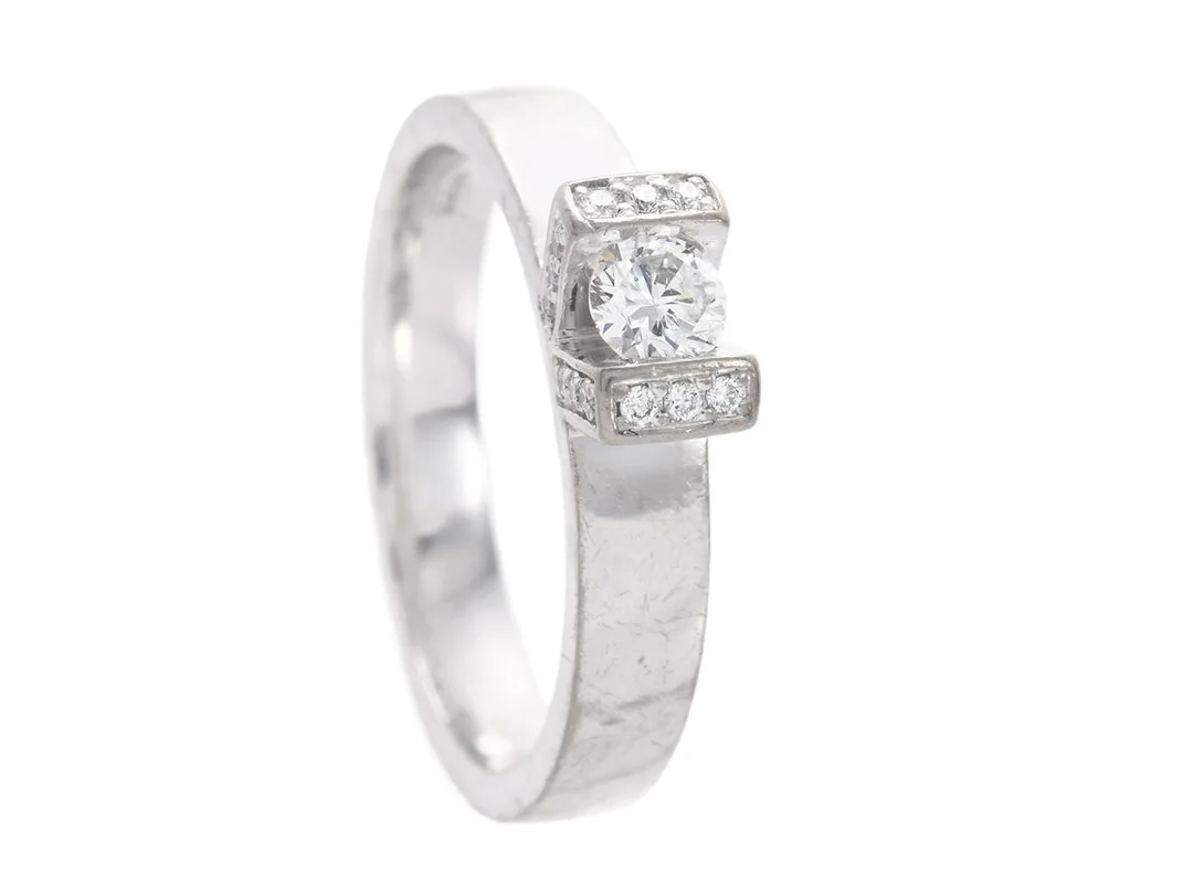 RING, 18K vitguld, briljantslipad diamant ca 0,22 ct, ca TW/SI, 30 briljantslipade diamanter ca 0,18 ctv, ca TW-W/VS-SI, Iduna, storlek 17,75 mm, vikt 7,4 g, mittstenen är lös i sin fattning och mindre nagg på kulett, slitage på skena. — Smycken/Ring — Kaplans