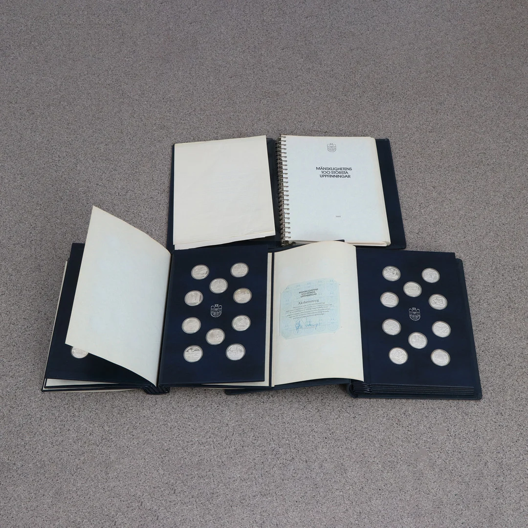 SAMLING MINNESMEDALJER I PÄRMAR, 100 MEDALJER. Sterlingsilver. Total vikt ca 1300 gram. Volym I & II samt tillhörande beskrivning. — Coins & Banknotes — Skånes Auktionsverk