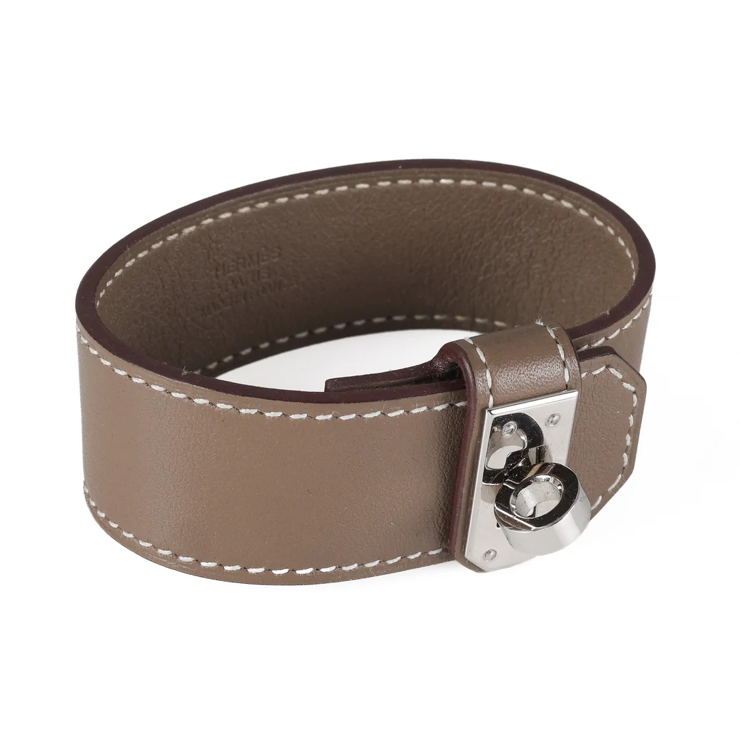 Hermés: A 'Kelly Twist' bracelet of brown calfskin. Size M/16.5 cm. France 2023. — Jewellery/Bracelets — Lauritz