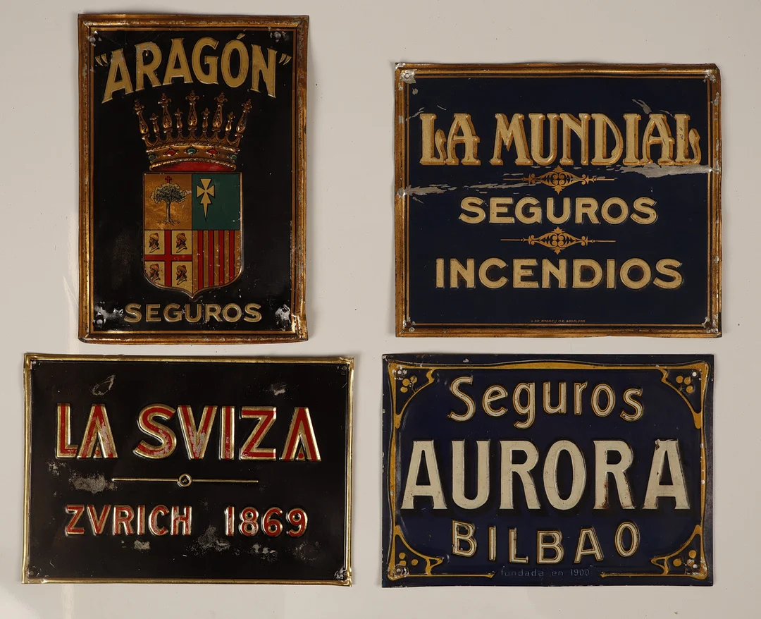 La Suiza y otras. 4 placas publicitarias en hojalata estampada y pintada. — Other collectables — Barcelona Auctions
