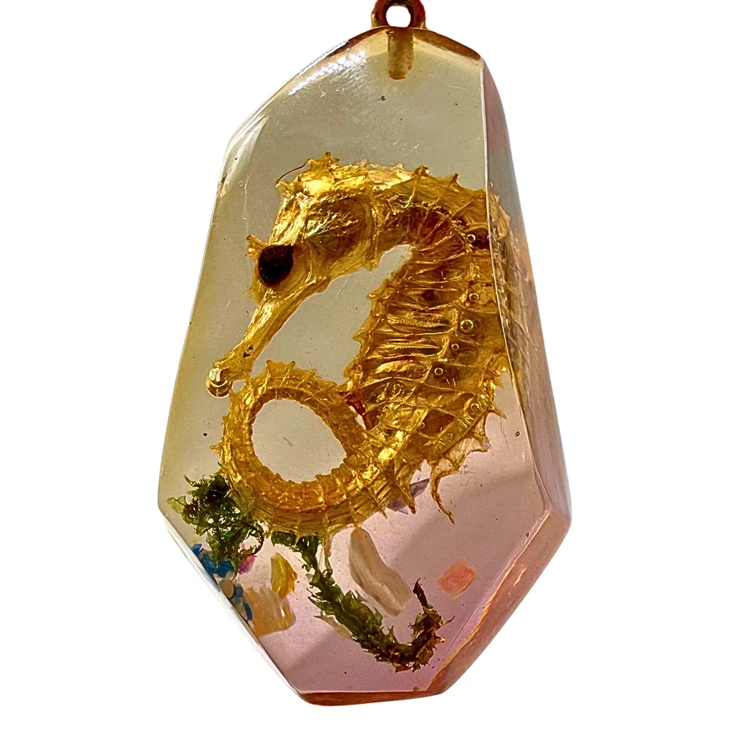 SEEPFERDCHEN-ANHÄNGER AUS BERNSTEINFARBENEN KUNSTHARZ. — Brooches & Pendants — Auktionshaus Stuber's Hammerschlag