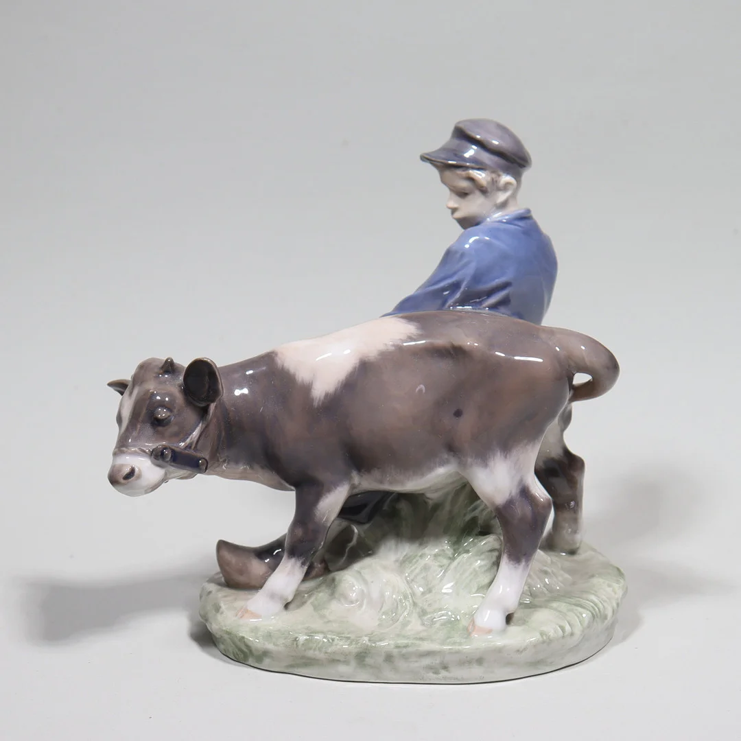CHRISTIAN THOMSEN. för Royal Copenhagen, figurin #772, pojke med kalv. — European — Markus Auktioner