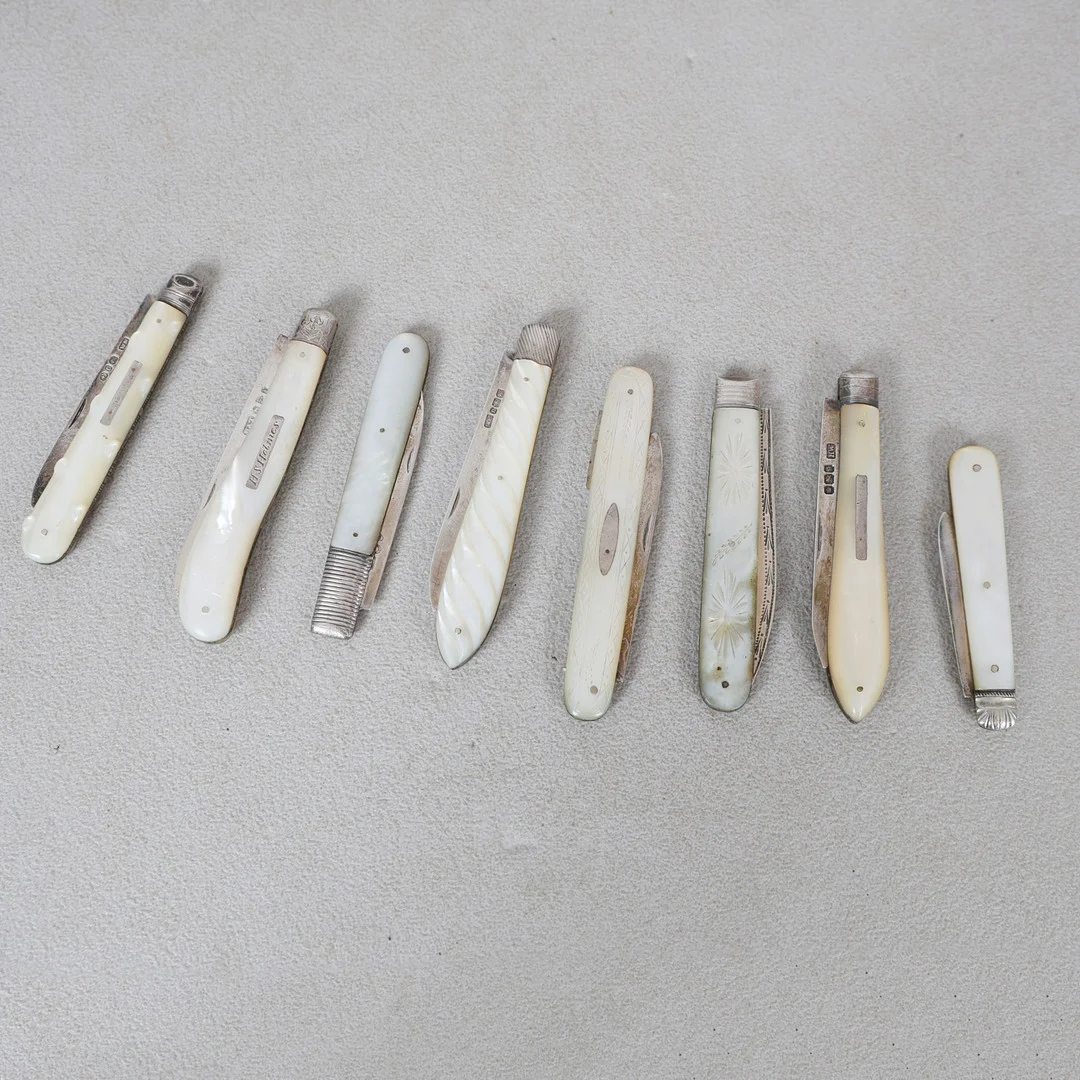 A COLLECTION OF EIGHT MOTHER OF PEARL AND SILVER BLADED FRUIT KNIVES (8). — Silver — Bishop & Miller