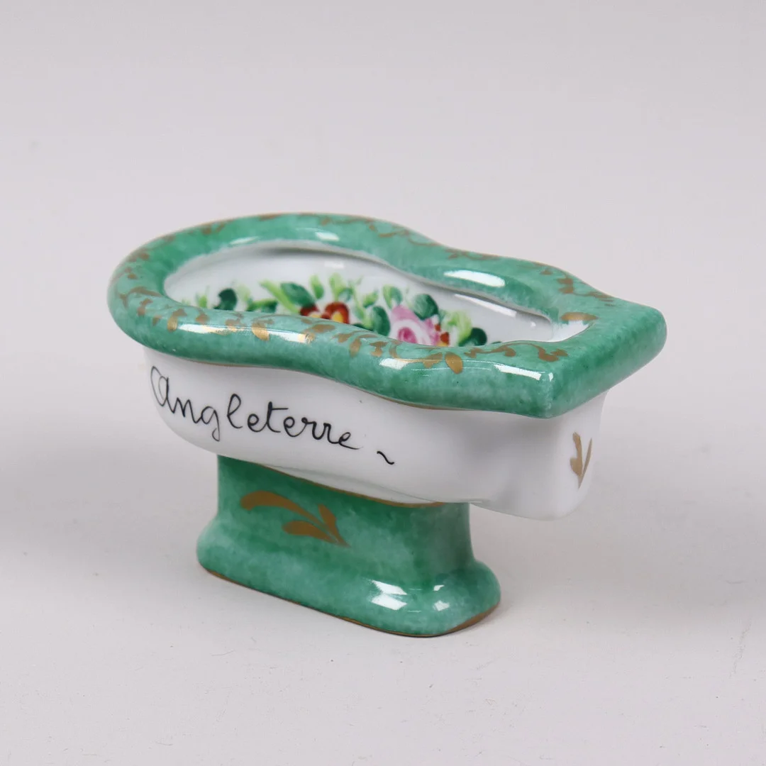 MINIATYR BIDÉ, porslin, text "De har ingen sån i England", 1900-talets mitt. — European — Markus Auktioner