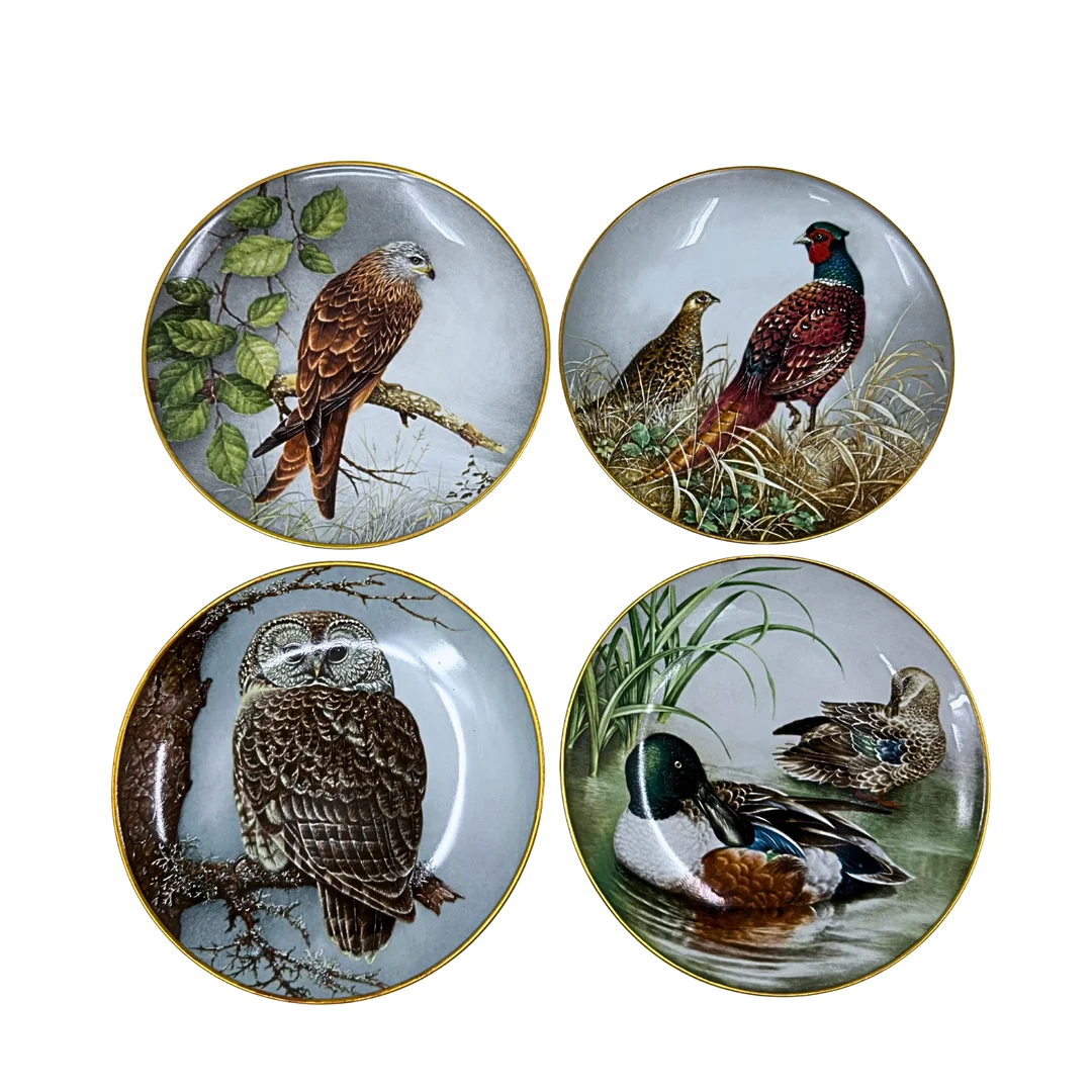 FRANKLIN MINT. VIER PORZELLAN-SAMMELTELLER MIT VERSCHIEDENEN TIERMOTIVEN UND GOLDRAND. — European — Auktionshaus Stuber's Hammerschlag