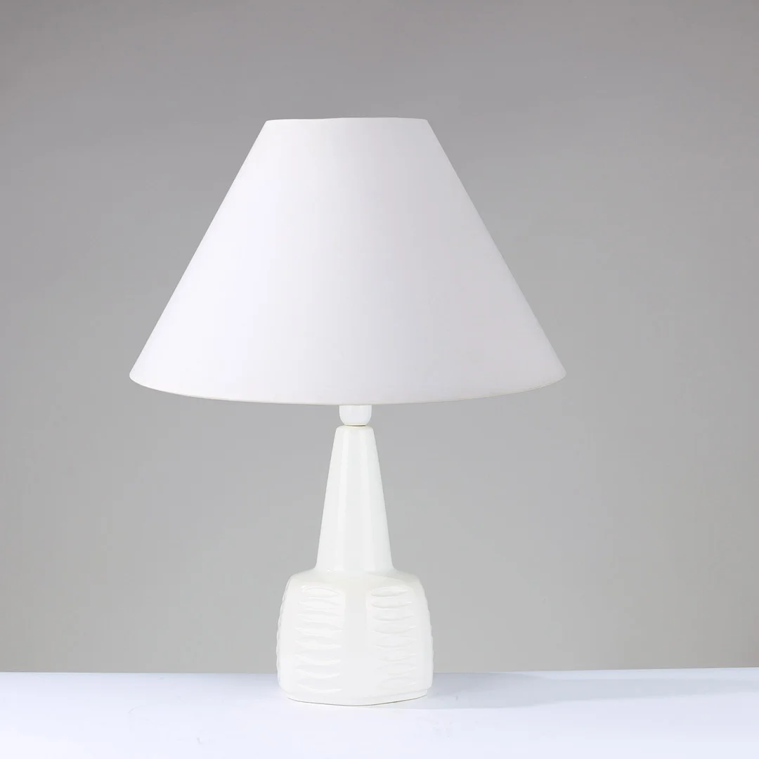 EINAR JOHANSEN (1906-80). Bordlampe af hvidglaseret keramik dekoreret med lodrette rækker af øjeformede relieffer, Søholm, Bornholm, Danmark, 1970/80'erne. — Table Lamps — Palsgaard Kunstauktioner